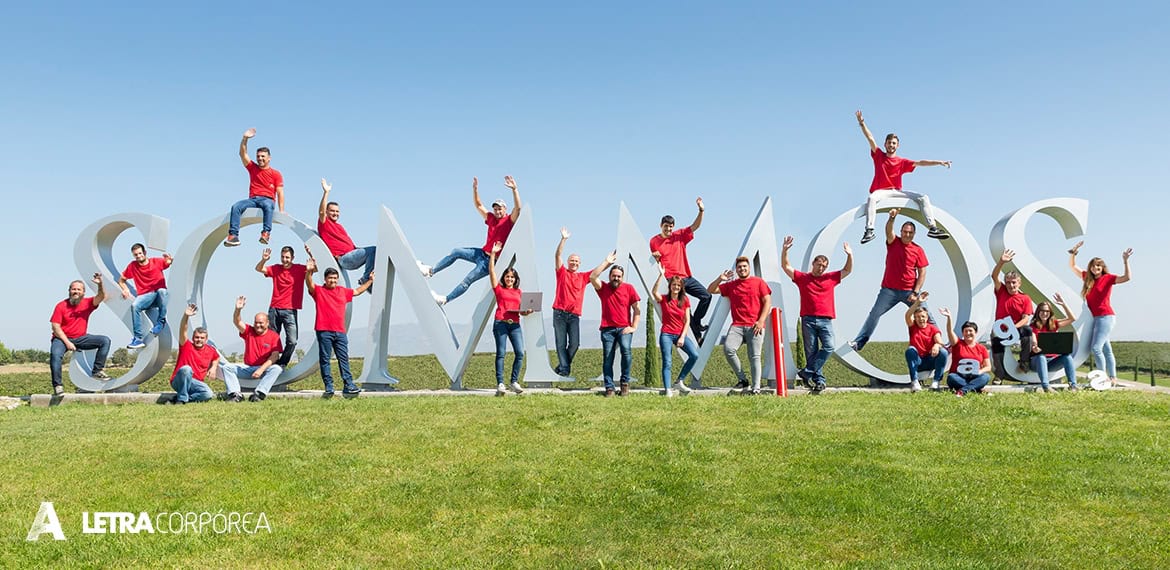 Letra corporea 3d grupo de personas en letras grandes y tridimensionales en exteriores.