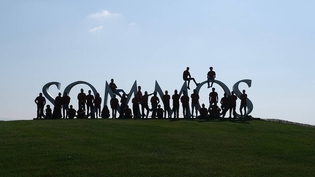 Personas interactuando con letras corpóreas 3D en un parque, creando una estructura visualmente impactante y creativa, ideal para eventos y experiencias visuales en ambientes exteriores.