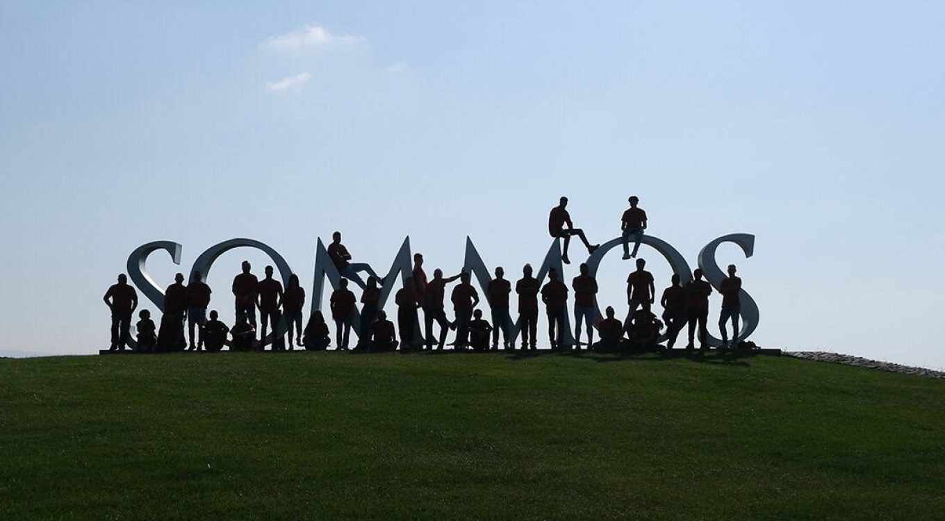 Personas interactuando con letras corpóreas 3D en un parque, creando una estructura visualmente impactante y creativa, ideal para eventos y experiencias visuales en ambientes exteriores.